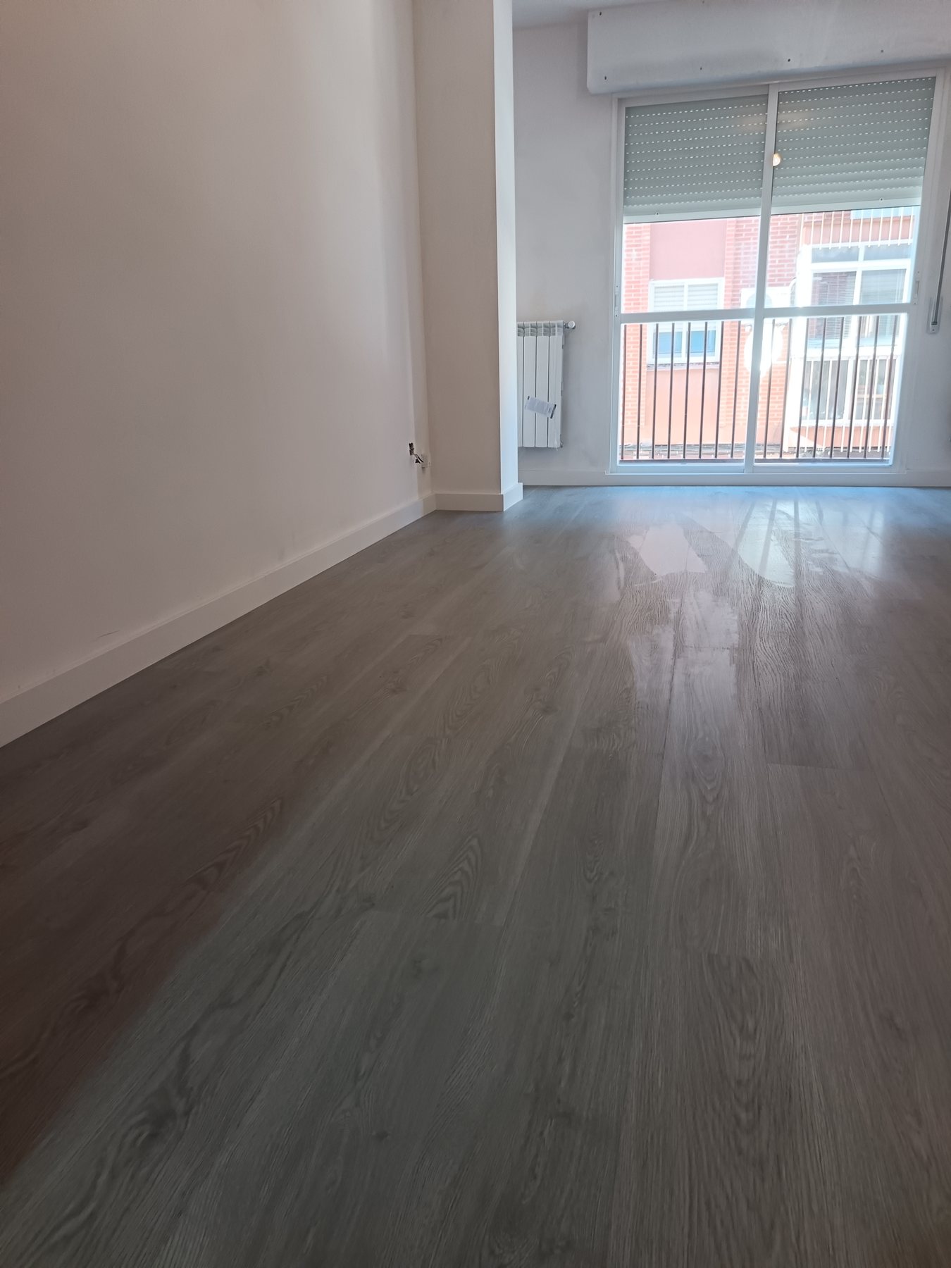 Estancia terminada con suelo laminado gris instalado por La Casa de Piedra en Zamora